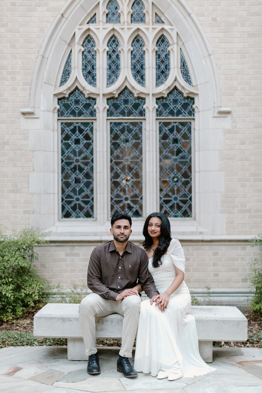 Angela and Ben sitting beneath a tall stained-glass window
