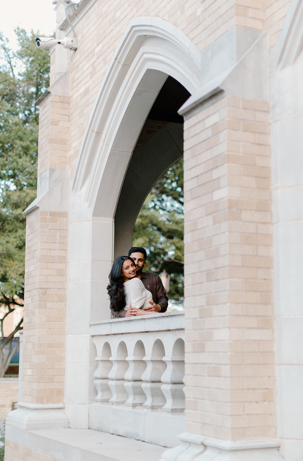 Angela and Ben sharing a moment on an arched balcony