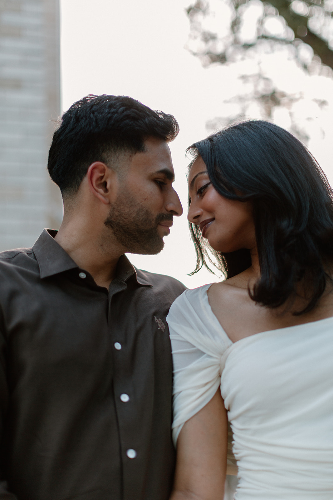 Angela and Ben lean close together in a sunlit portrait