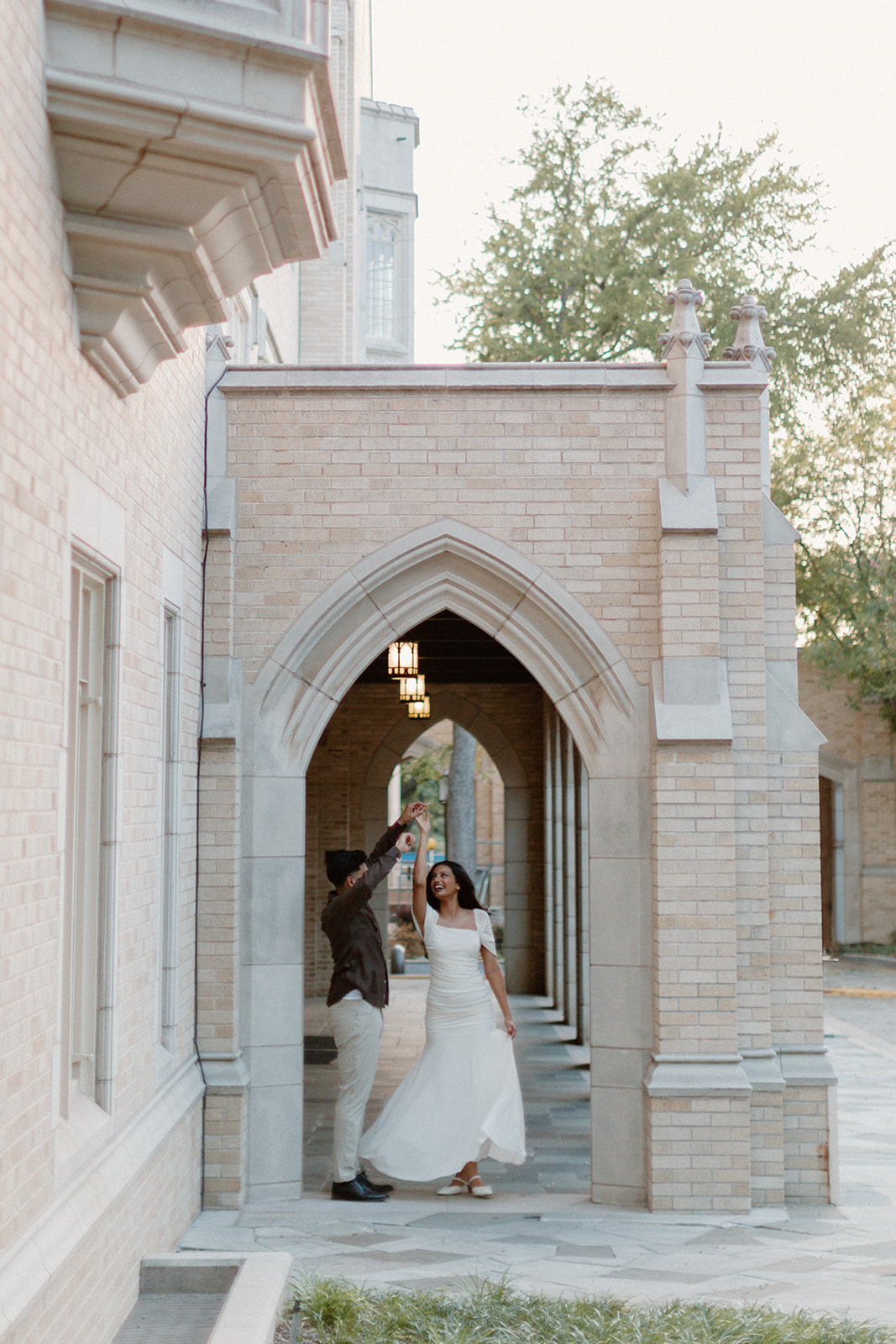Ben twirls Angela beneath a row of stone arches