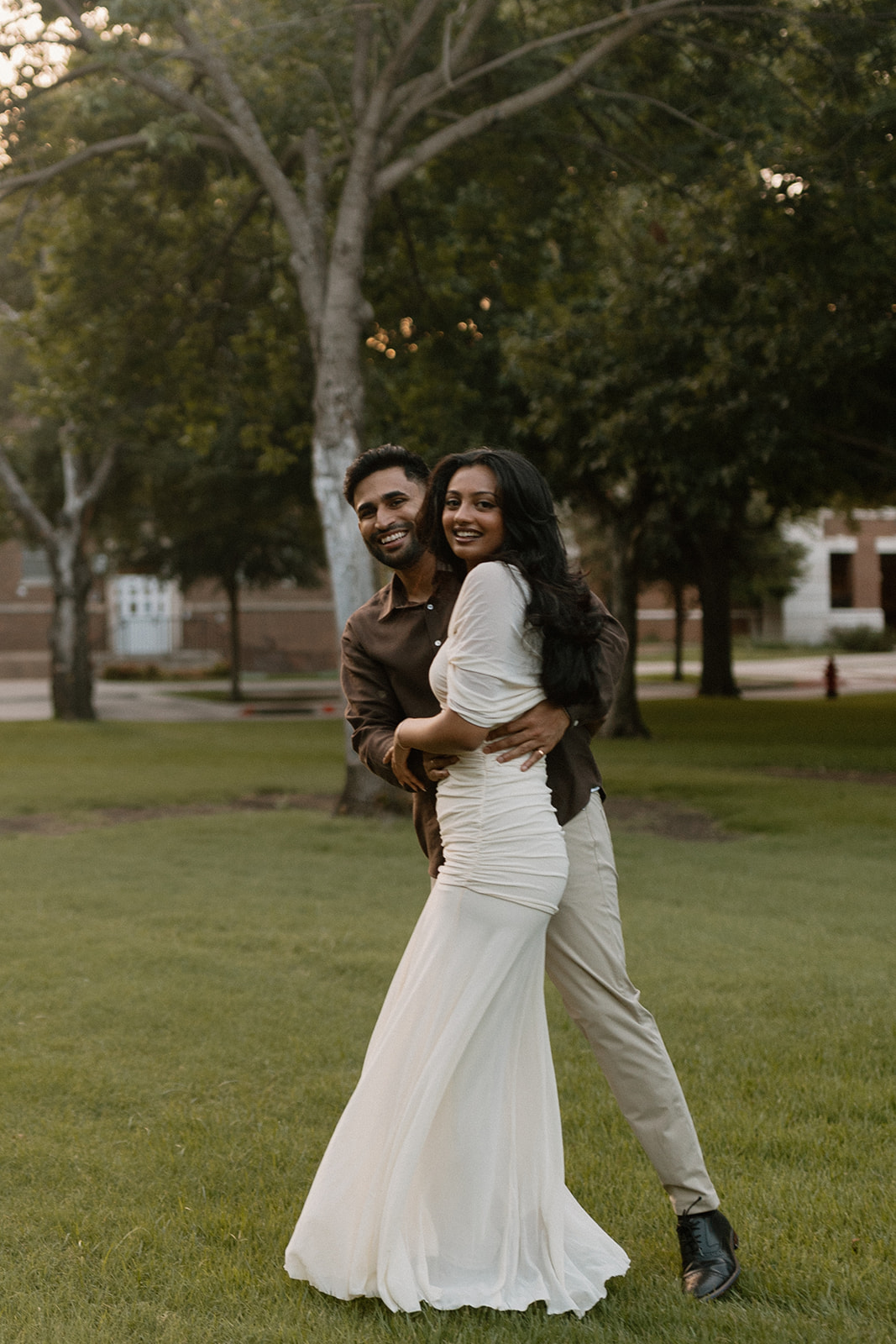 Angela and Ben smiling together on the lawn at dusk