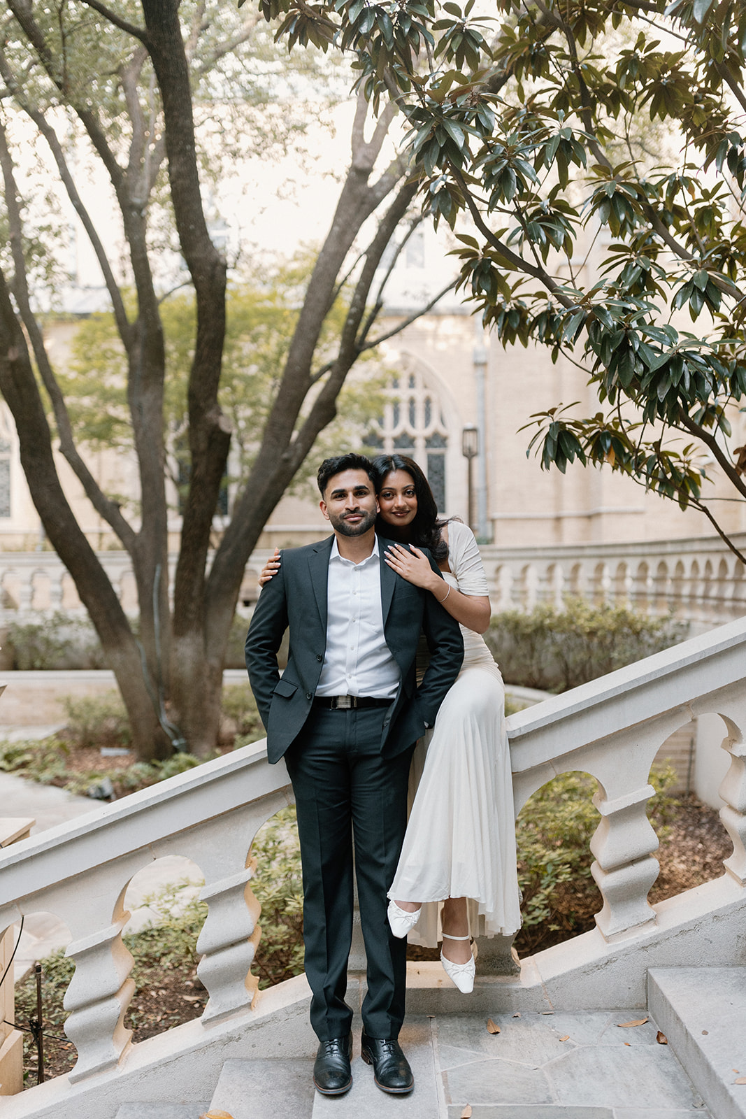 Angela sits on a stone railing with her arms around Ben
