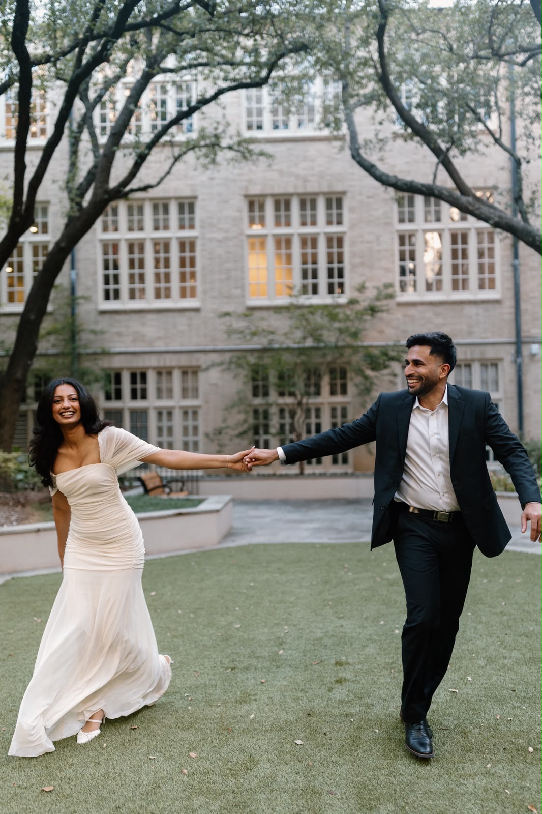 Angela and Ben smile while holding hands