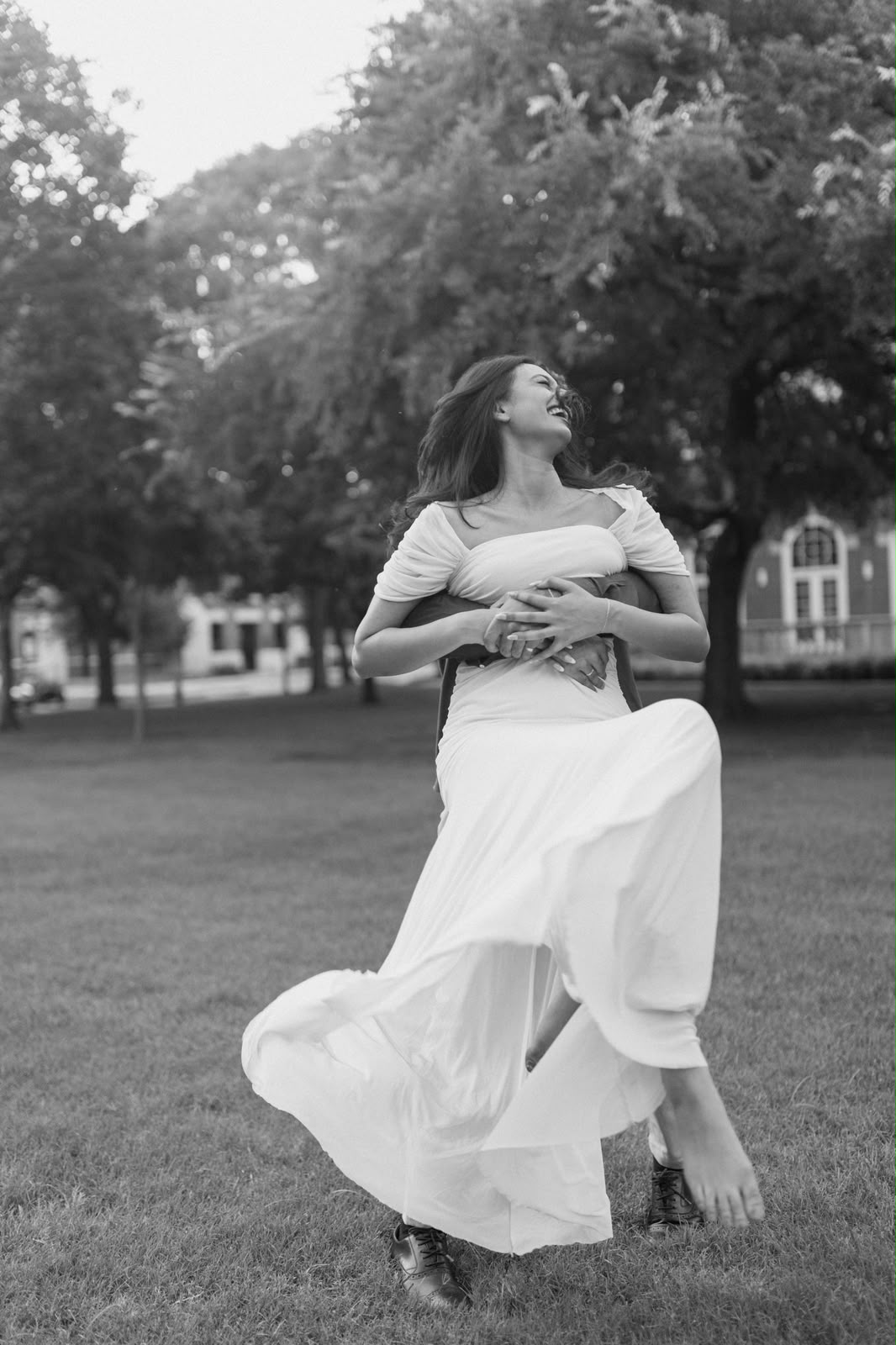 Angela laughs while Ben twirls her on the lawn