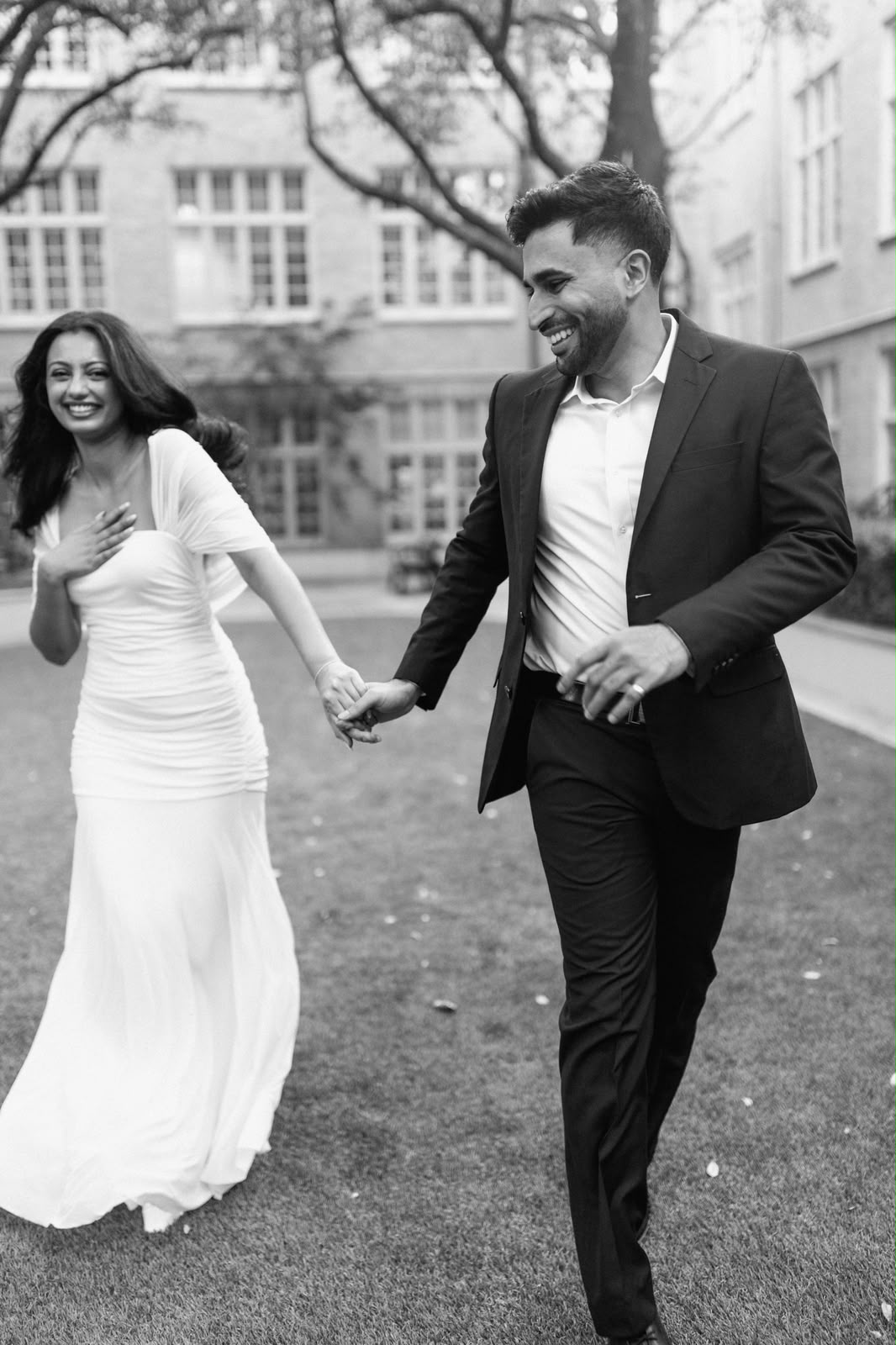 Angela and Ben laugh while walking hand in hand